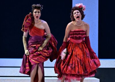 Two opera singers in elaborate gowns perform with emotion, on a stage. From the opera "La cenerentola" with the Manitoba Opera 2022.