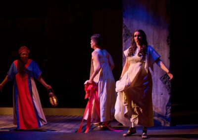 Three actresses perform in a Greek-style tragedy with costumes and a lantern. From the opera "Pomegranate" with the Canadian Opera Company 2023.